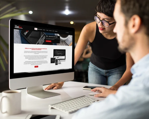 Small business website design review on desktop computer with client and designer